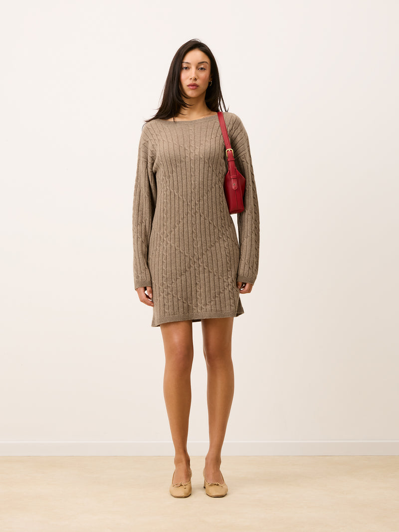 Beige knit short dress seen from the front, with a red bag and beige shoes.