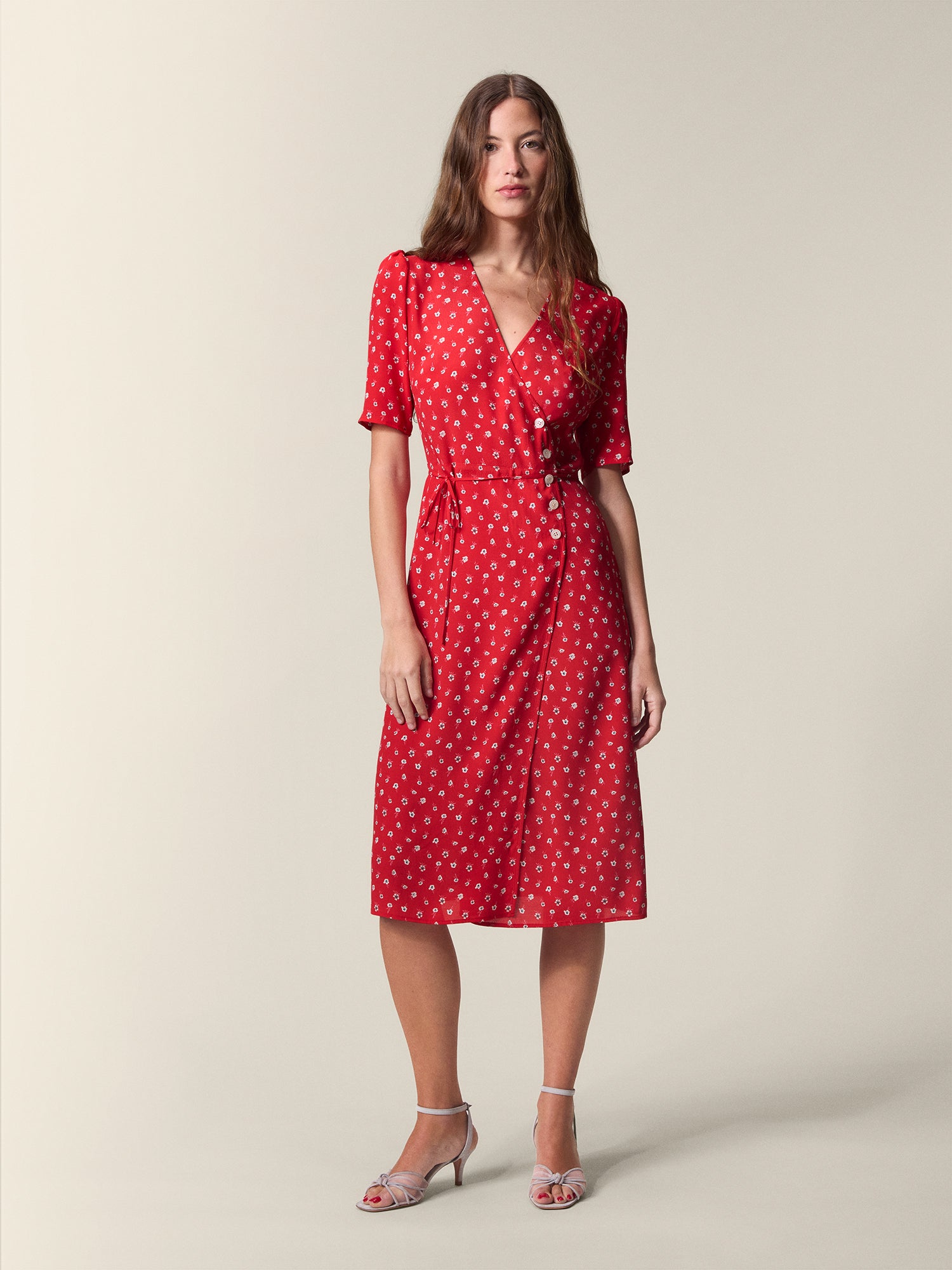 Gabin red wrap dress with white flowers for women, tied at the waist, seen from the front.