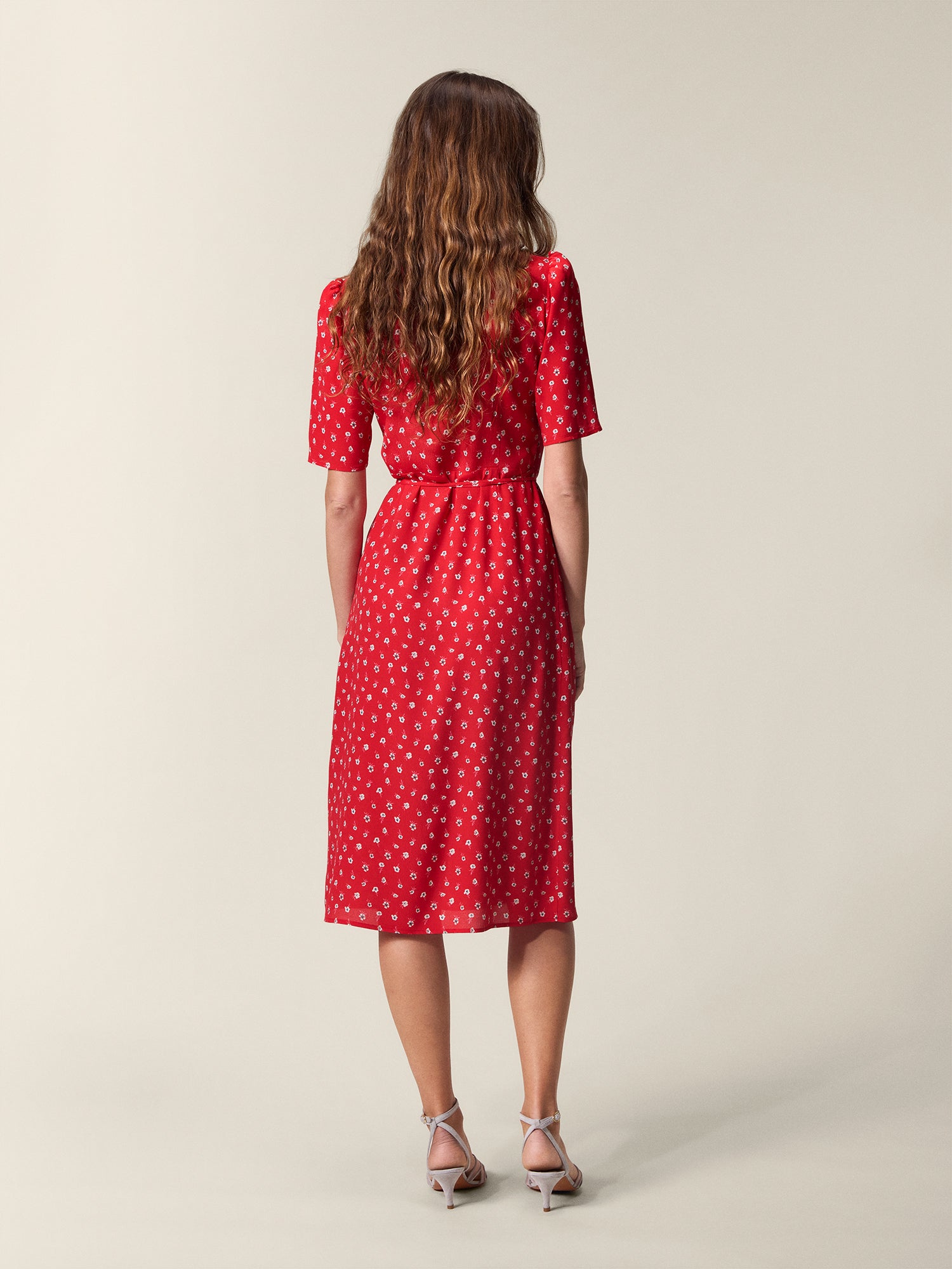 Gabin red dress with white flowers seen from the back, tied at the waist.