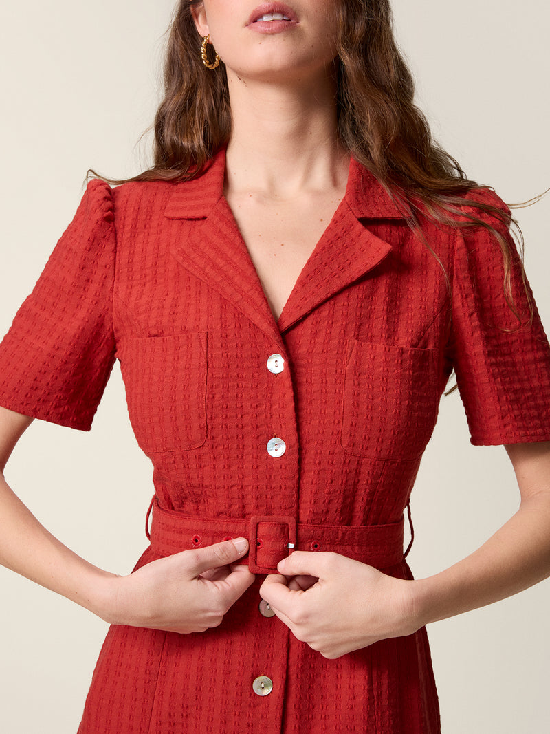 Close up on the collar, pearl buttons and belt of the red Raella dress.
