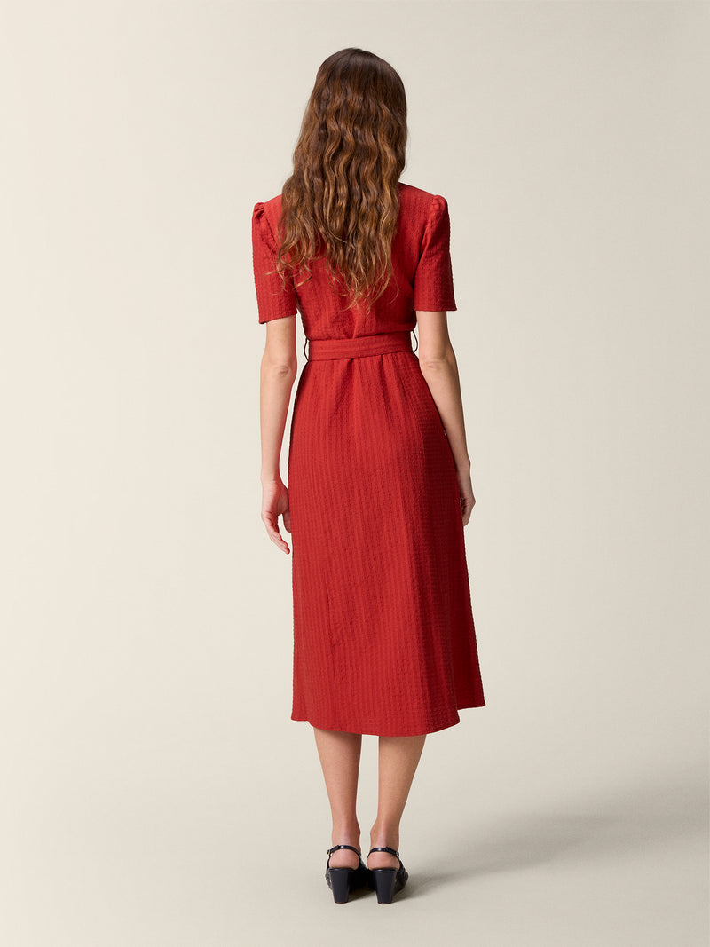 Back view of the red Raella dress, belted at the waist.
